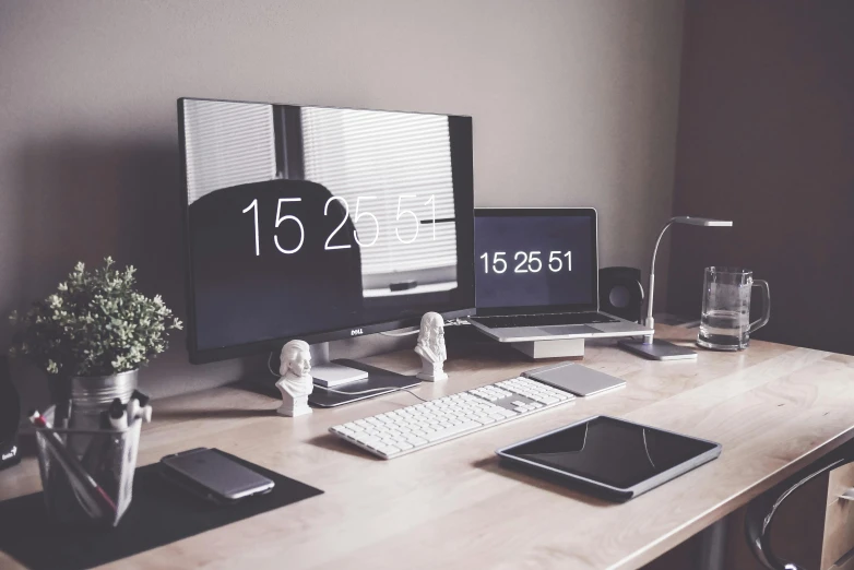 a desktop computer sitting on top of a wooden desk, trending on unsplash, clock iconography, many screens, grey and dark theme, at home