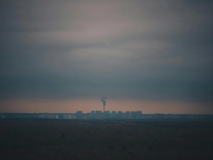 an airplane that is flying in the sky, inspired by Elsa Bleda, tonalism, building in the distance, nuclear waste, telephoto long distance shot, grey sky