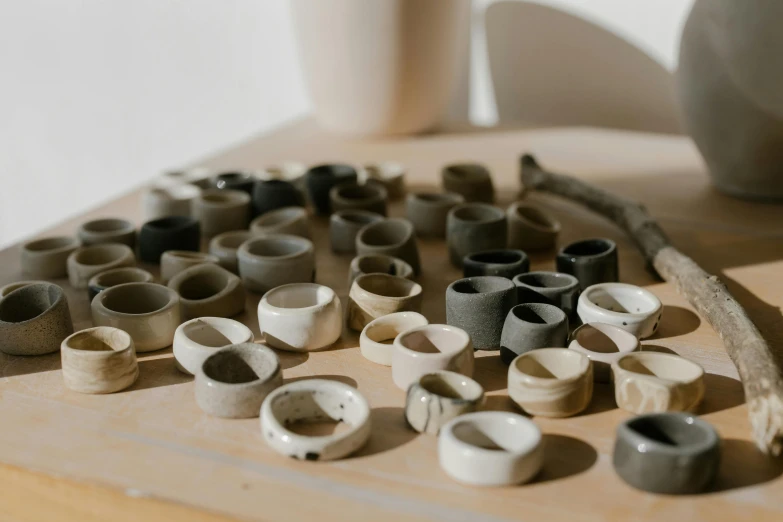 a table topped with bowls and cups on top of a wooden table, by Jessie Algie, trending on unsplash, minimalism, rings, 3 d clay sculpture, many pipes, made in tones of white and grey