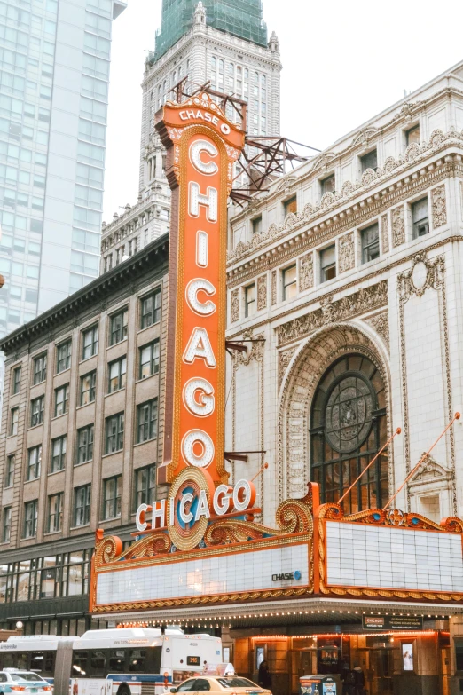 a theater marquee with a clock tower in the background, by Robbie Trevino, trending on unsplash, art nouveau, chicago, 🚿🗝📝, promo image, buildings carved out of stone