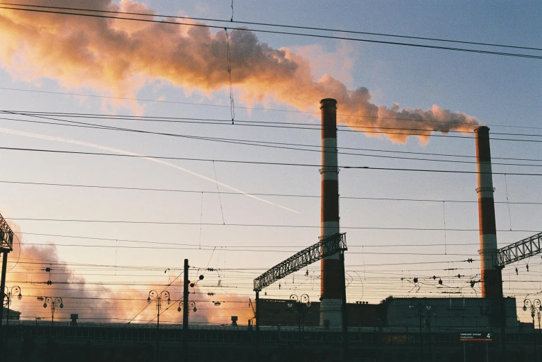 a factory with a lot of smoke coming out of it, by Carey Morris, pexels contest winner, at the golden hour, kodak portra, chimney, heavy lines