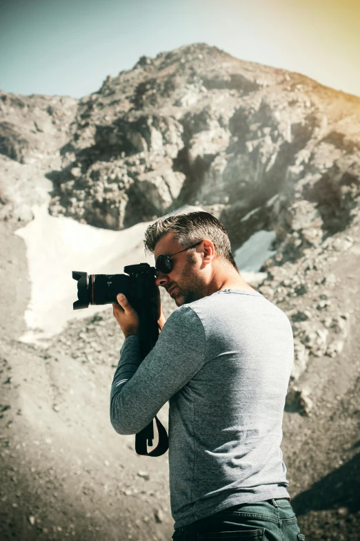 a man taking a picture of a mountain with a camera, by Daren Bader, mount doom, portrait shot 8 k, hasselblad photo, summer season