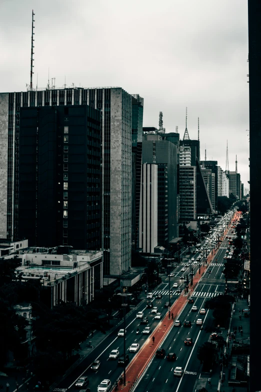 a city filled with lots of tall buildings, an album cover, by Xavier Blum Pinto, pexels contest winner, modernism, avenida paulista, dreary atmosphere, traffic, panorama