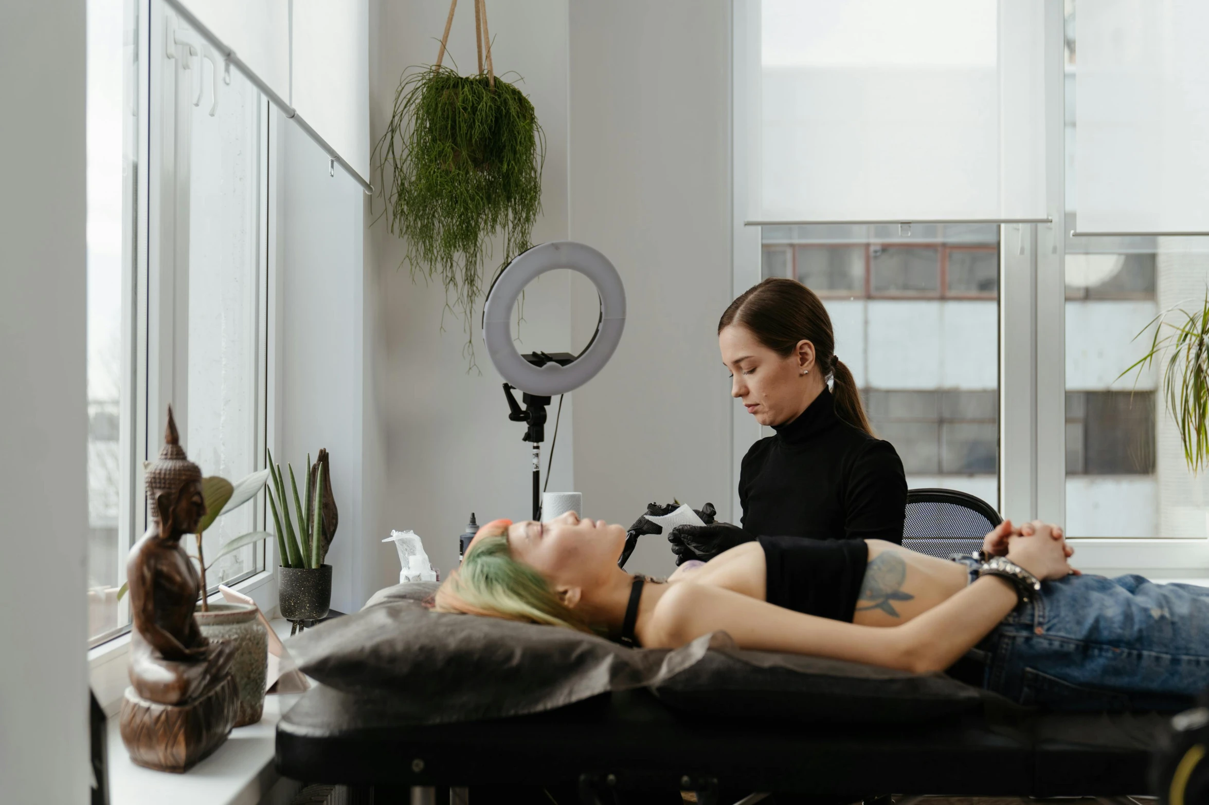 a woman laying on top of a table in a room, a tattoo, by Niko Henrichon, pexels contest winner, acupuncture treatment, sydney hanson, in white room, woman holding another woman