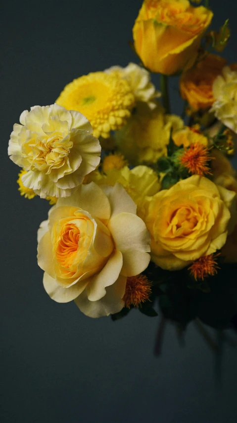 a vase filled with yellow and white flowers, a still life, unsplash, detail shot, rose-brambles, shot on sony a 7, various styles