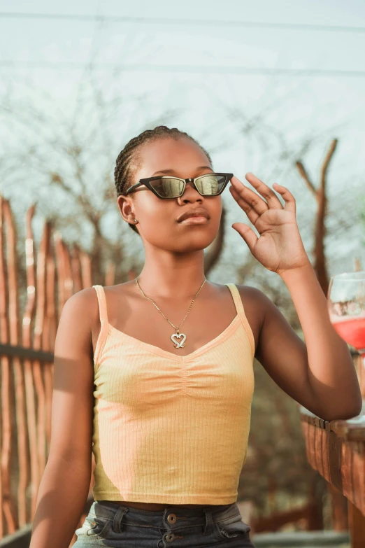 a woman in a yellow tank top and denim shorts, trending on pexels, samburu, woman with rose tinted glasses, (night), instagram post