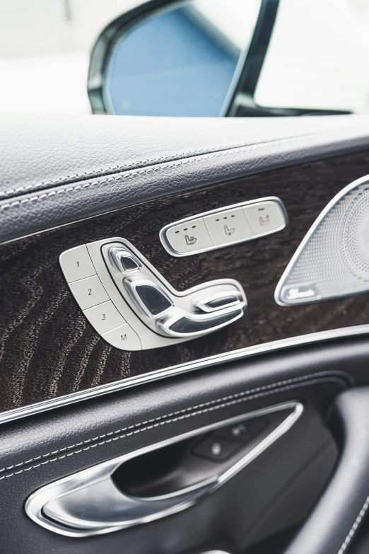 a close up of the interior of a car, silver insignia, polished with visible wood grain, 4l, mercedes