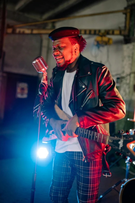 a man that is standing in front of a microphone, inspired by Gerard Sekoto, happening, holding a electric guitar, production photo, vibrant mood, kano)