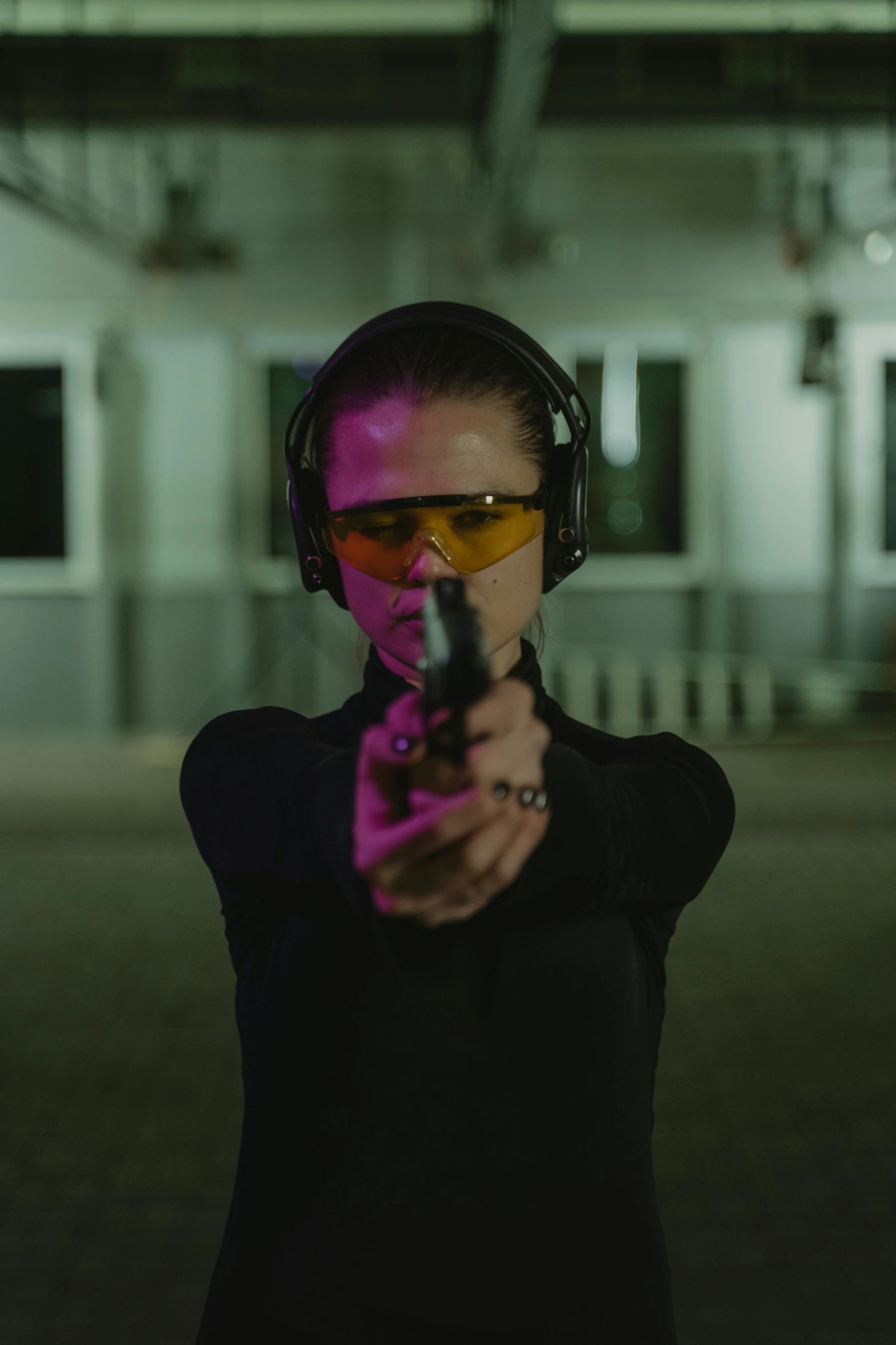 a woman holding a gun and wearing headphones, with anamorphic lenses, holding a glock, ( ( theatrical ) ), sleek