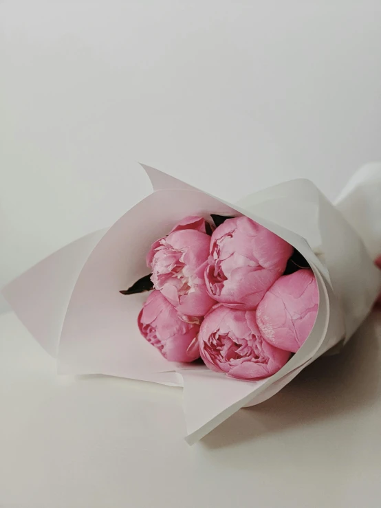 a bunch of pink flowers sitting on top of a table, intimately holding close, smooth matte, very crisp, wrapped