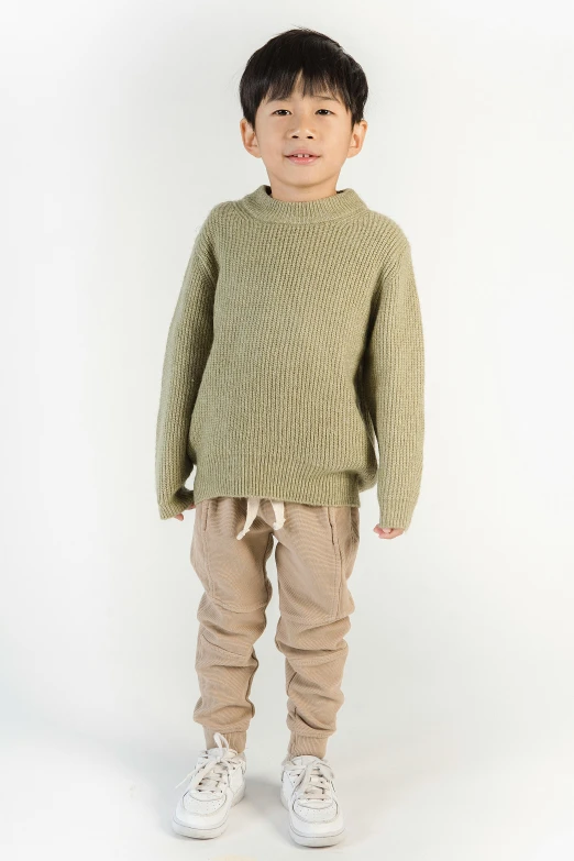 a young boy in a green sweater and khaki pants, wearing an oversized sweater, detailed product shot, 2023 4k, about