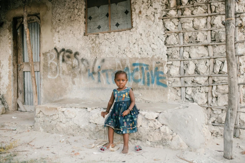 a little girl standing in front of a building, auto-destructive art, jamaican vibe, portrait featured on unsplash, standing on rocky ground, high quality wallpaper