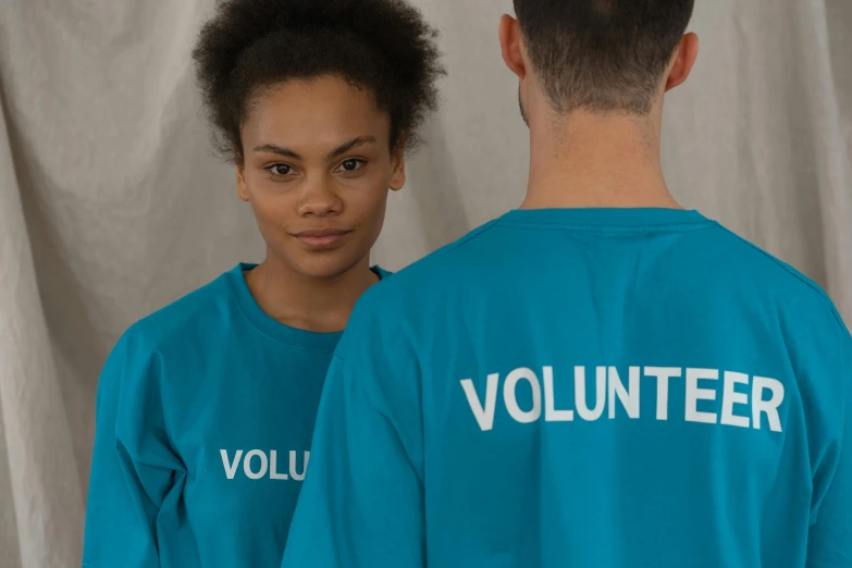 a man and a woman wearing volunteer shirts, by Matija Jama, pexels contest winner, cyan, female model, thumbnail, small