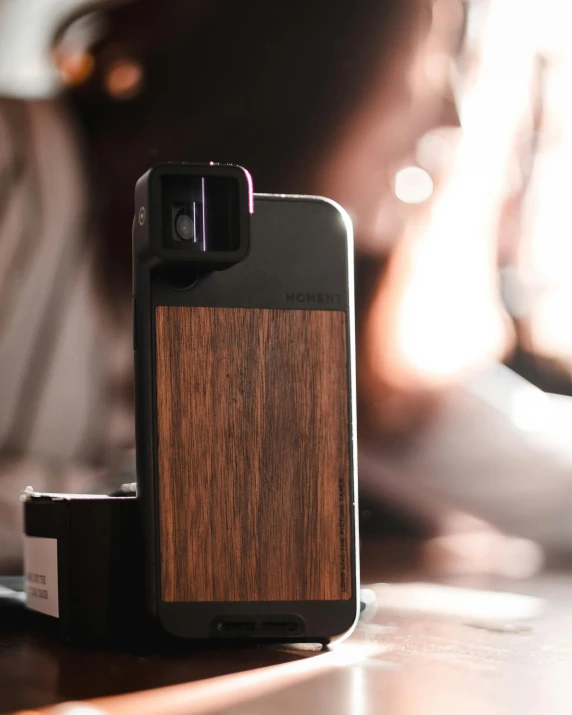 a close up of a cell phone on a table, a picture, case, anamorphic lenses, walnut wood, medium format