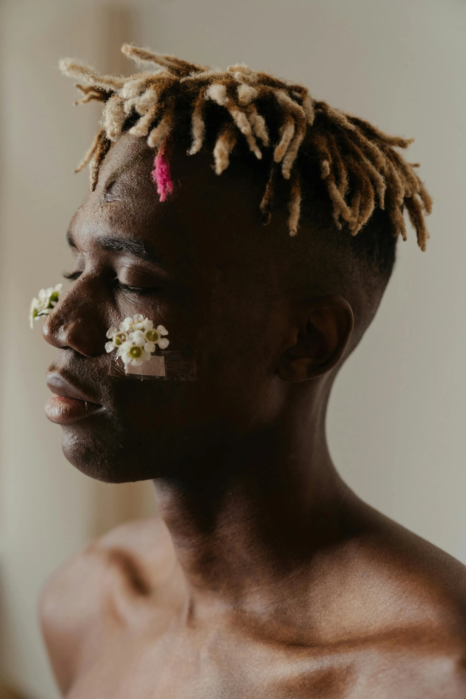 a man with dreadlocks and flowers in his hair, by Dulah Marie Evans, trending on pexels, afrofuturism, small nose with freckles, shaved sides, tyler the creator, with brown skin