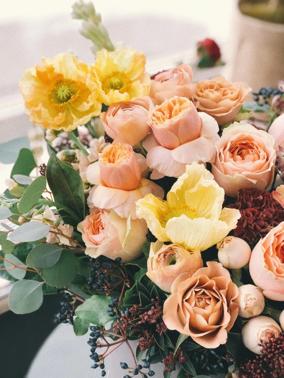 a bouquet of flowers sitting on top of a table, pale orange colors, roses and tulips, upclose, designed for cozy aesthetics!