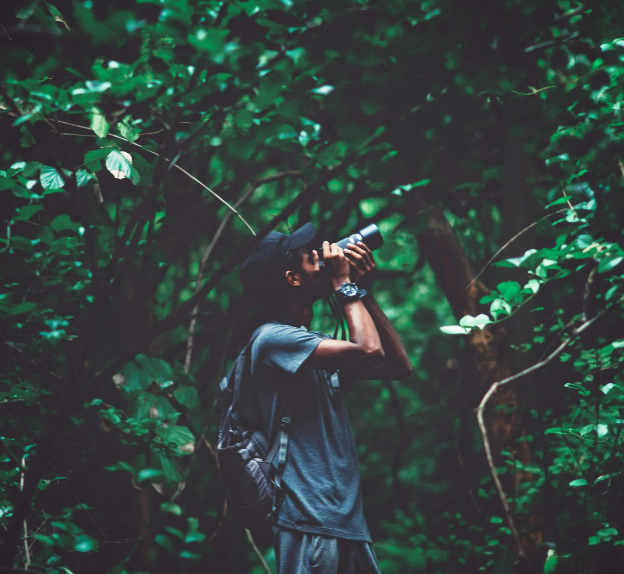 a man standing in the middle of a forest drinking from a bottle, inspired by Elsa Bleda, pexels contest winner, sumatraism, jamaica, paparazzi photo, hunting, covered in plants