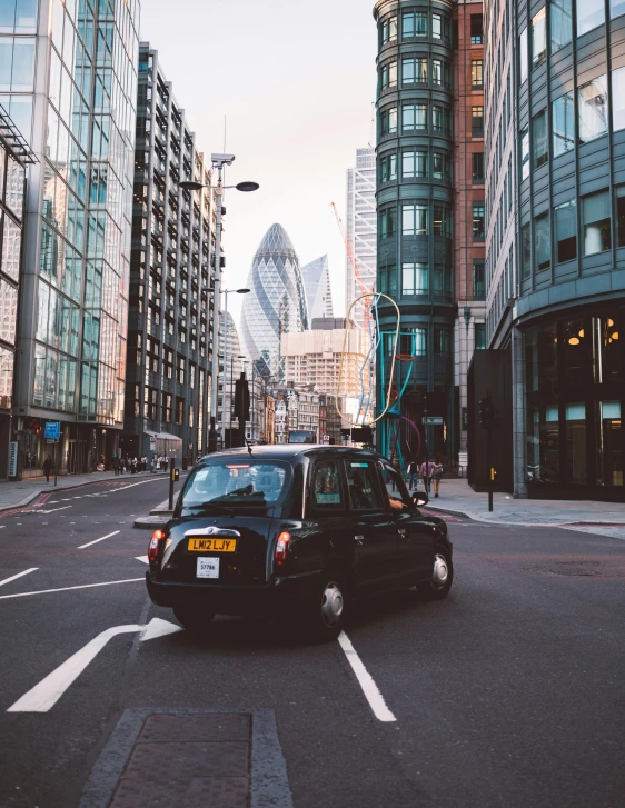 a car driving down a city street next to tall buildings, pexels contest winner, london, taxi, square, thumbnail