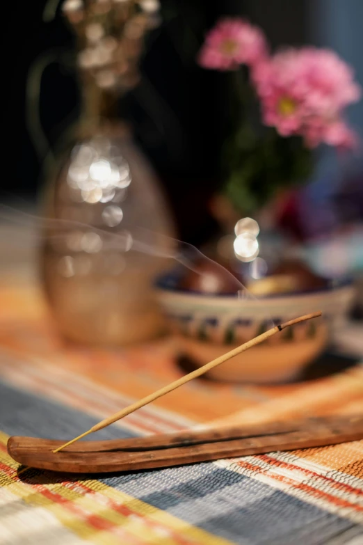 a wooden spoon sitting on top of a table, incense, vibrant setting, medium close shot, fine lines