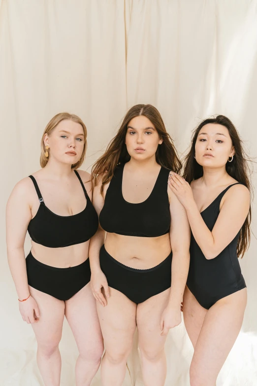 three women in black swimsuits standing next to each other, inspired by Vanessa Beecroft, unsplash, round-cropped, various colors, in kaethe butcher, wearing bra