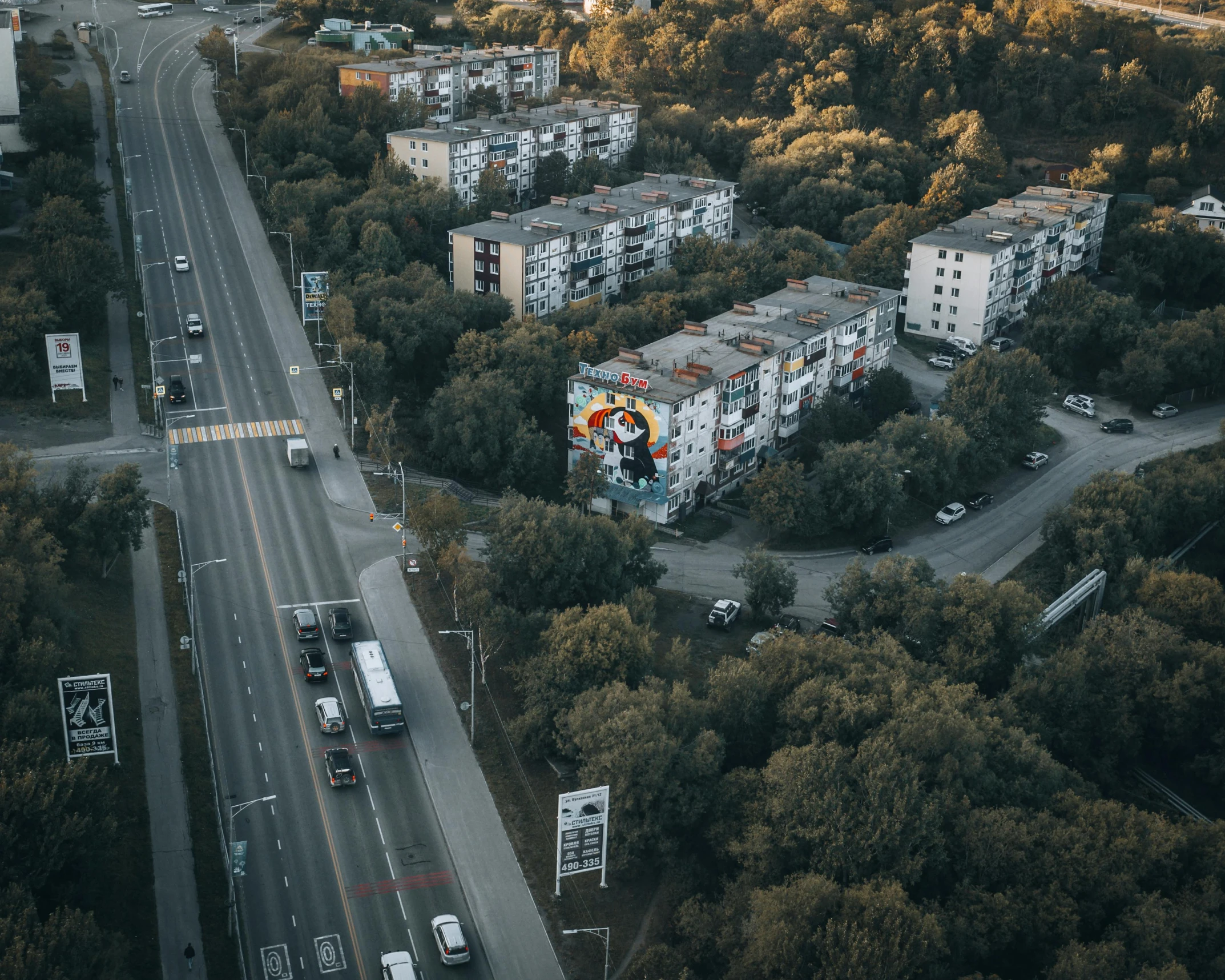 a city filled with lots of traffic next to tall buildings, by Micha Klein, pexels contest winner, street art, soviet suburbs, above a forest, superhero, high res 8k