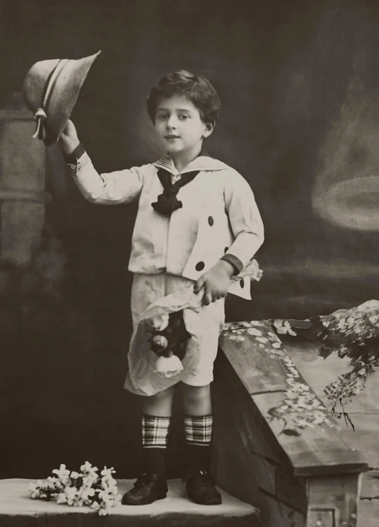 a black and white photo of a young boy holding a hat, by Lucia Peka, dada, sailor uniform, queen margherita of savoy, gal yosef, promo image