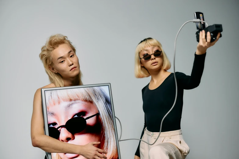 a woman taking a picture of another woman with a camera, an album cover, inspired by Wang Duo, unsplash, neo-dada, modeling photograph kerli koiv, with square glasses, bang olufsen, asian women