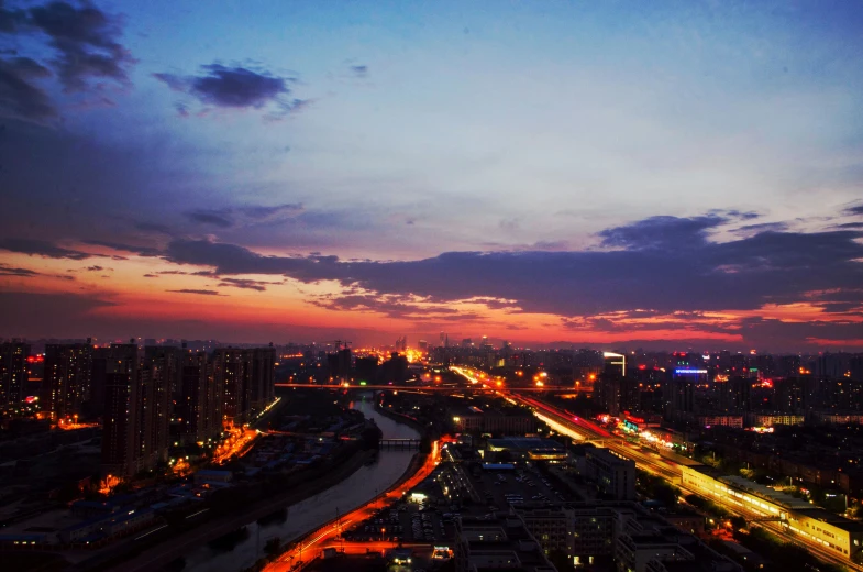 an aerial view of a city at night, an album cover, by Shang Xi, pexels contest winner, happening, orange and blue sky, early evening, slight overcast, summer sunset
