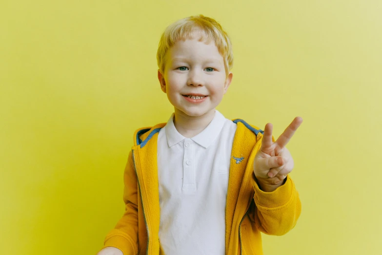 a little boy standing in front of a yellow wall, peace sign, albino white pale skin, 15081959 21121991 01012000 4k, on a yellow canva