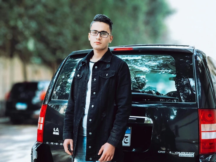 a man standing in front of a black car, an album cover, pexels contest winner, realism, jewish young man with glasses, ahmad merheb, around 1 9 years old, hd quality