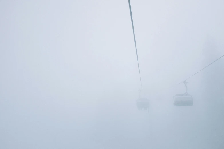 a couple of people riding a ski lift in the fog, by Tobias Stimmer, pexels contest winner, minimalism, snowstorm ::5, zoomed out, pale blue fog, grayish