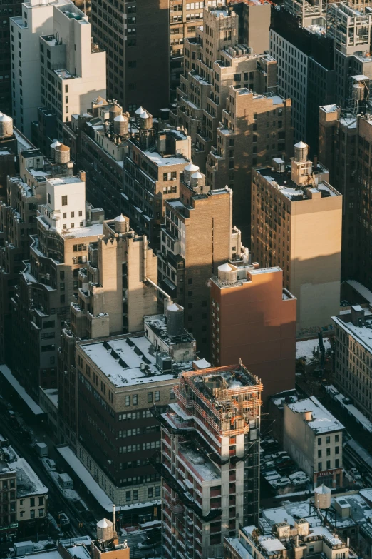 a city filled with lots of tall buildings, unsplash contest winner, modernism, (snowy new york in background), late afternoon light, sharp roofs, promo image