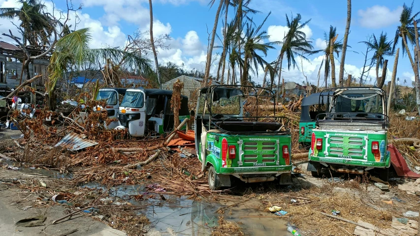 a couple of trucks that are sitting in the dirt, auto-destructive art, coconut trees, collapsed buildings, avatar image, trending photo