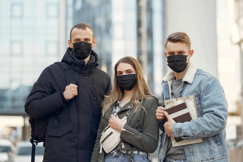 a group of three people standing next to each other, by Nicolette Macnamara, shutterstock, black bandana mask, academic clothing, urban surroundings, thumbnail