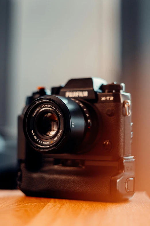 a camera sitting on top of a wooden table, by Reuben Tam, pexels contest winner, medium format. soft light, lovingly looking at camera, unsplash 4k, towering over the camera