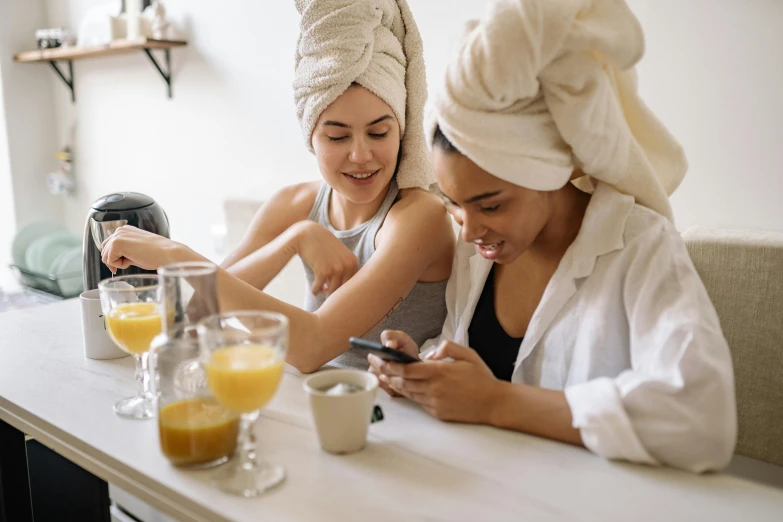 a couple of women sitting next to each other on a table, trending on pexels, happening, wearing a towel, tech robes, manuka, snapchat photo