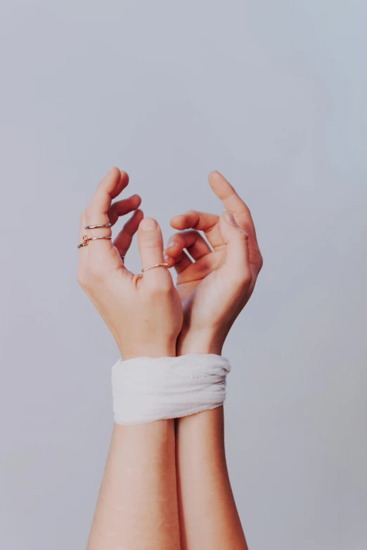 a pair of hands tied to a wrist, an album cover, inspired by Elsa Bleda, trending on pexels, aestheticism, anjali mudra, simple aesthetic, ilustration, high cohesiveness