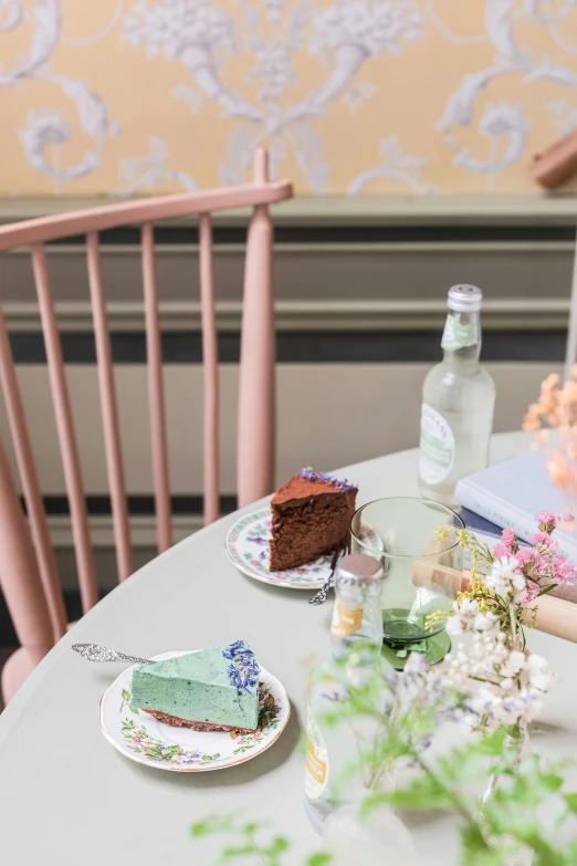 a close up of a plate of food on a table, by Lucette Barker, rococo, green and pink colour palette, chocolate frosting, cafe interior, product shot