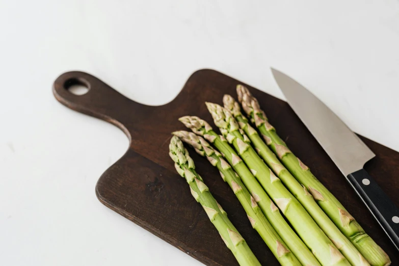 asparagus spears on a cutting board with a knife, unsplash, ilustration, high resolution photograph, no - text no - logo, complete scene