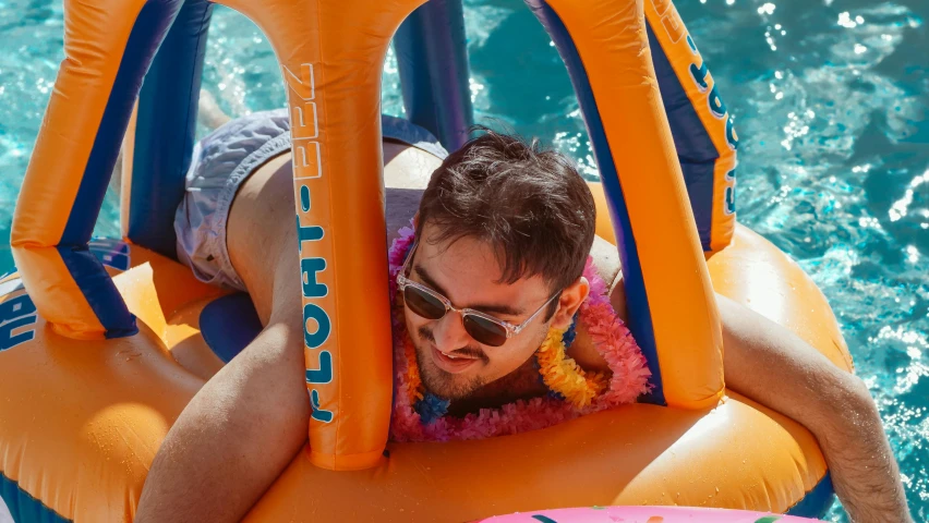 a man laying on an inflatable raft in a pool, by Lee Loughridge, pexels contest winner, rhett and link, orange sunglasses, avatar image, at a beach party in ibiza