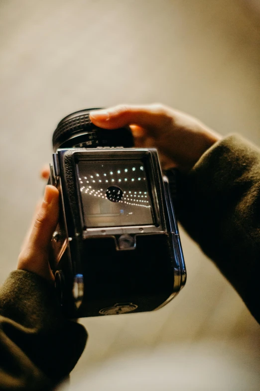 a close up of a person holding a camera, a hologram, unsplash, visual art, hasselblad medium format, jaquet droz, flashing lights, on display