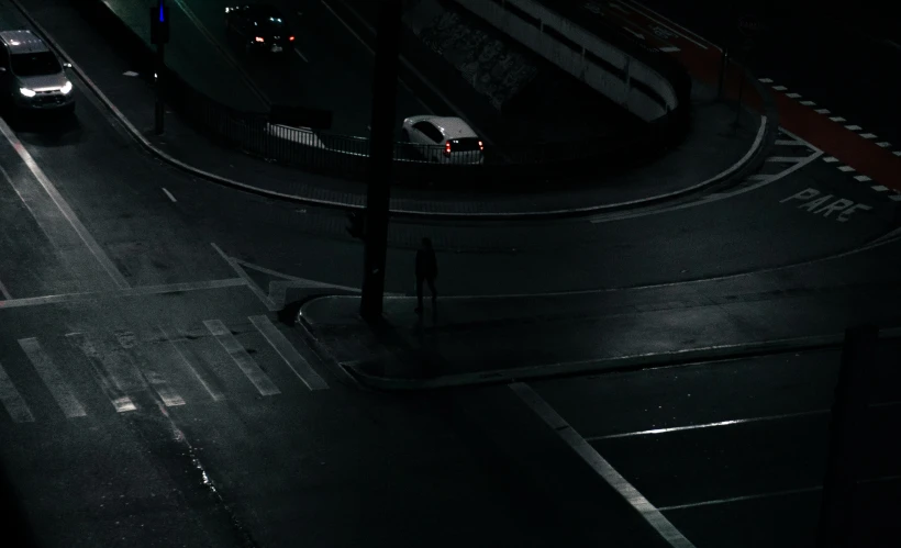 a couple of cars driving down a street at night, inspired by Elsa Bleda, pexels contest winner, conceptual art, dark figures walking, standing on street corner, a lonely woman, intersection