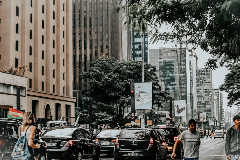 a group of people crossing a busy city street, by João Artur da Silva, pexels contest winner, visual art, parked cars, skyscrapers with greenery, background image, brazil