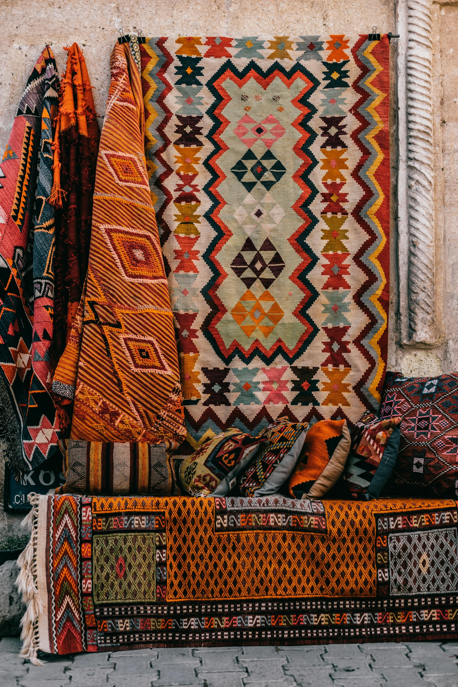 a group of rugs sitting on top of a sidewalk, by Daniel Lieske, trending on unsplash, greek fabric, square, demur, tapestries hanging from ceiling