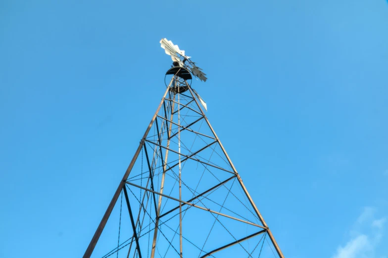 a bird sitting on top of a metal tower, windmill, profile image