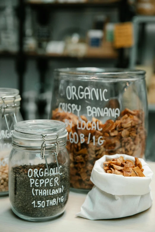 a table topped with jars filled with different types of granola, renaissance, organic lines, banana, daily specials, organic steel