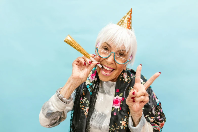 an older woman making a peace sign with her fingers, an album cover, trending on pexels, party hats, happy birthday, long tongue, portrait of a old