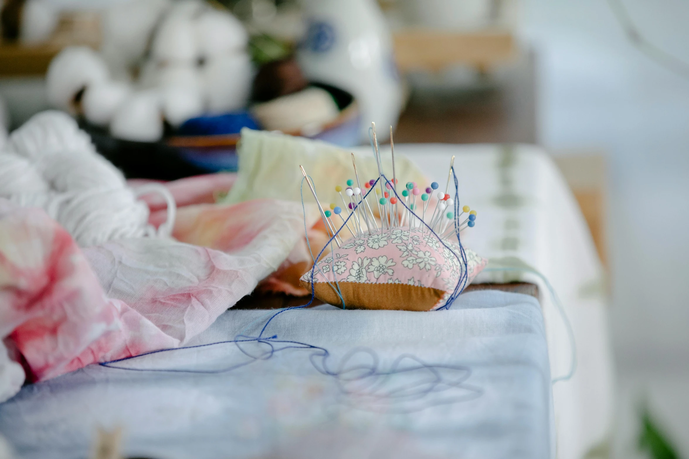 a table topped with a cake covered in sprinkles, a cross stitch, by Alice Mason, unsplash, process art, crown made of fabric, silver crown, in a workshop, blue and pink shift