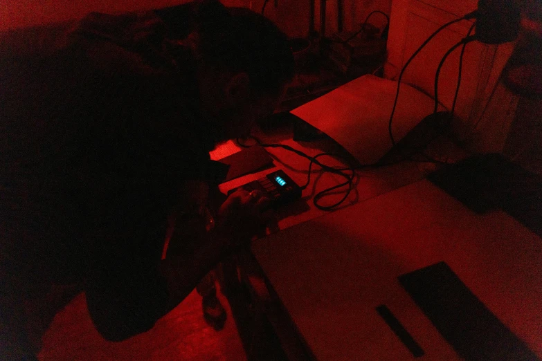 a cell phone sitting on top of a table under a red light, an etching, holography, in a darkly lit laboratory room, mana shooting from his hands, low quality photograph, tranding on art station