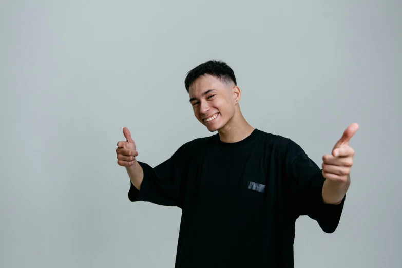 a man in a black shirt giving a thumbs up, inspired by Gang Hui-an, pexels contest winner, frontal pose, deep dimples, chillhop, very minimal